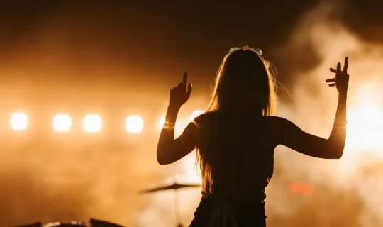 a woman standing in front of a crowd at a concert