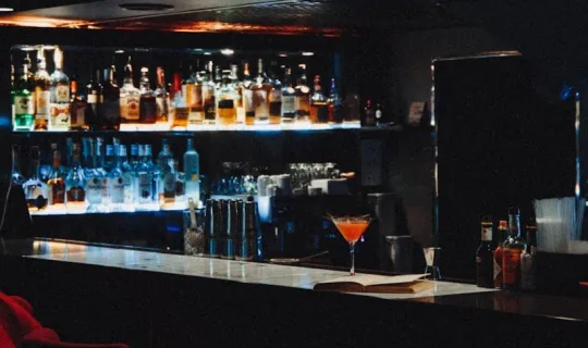 brown wooden bar stools with bottles